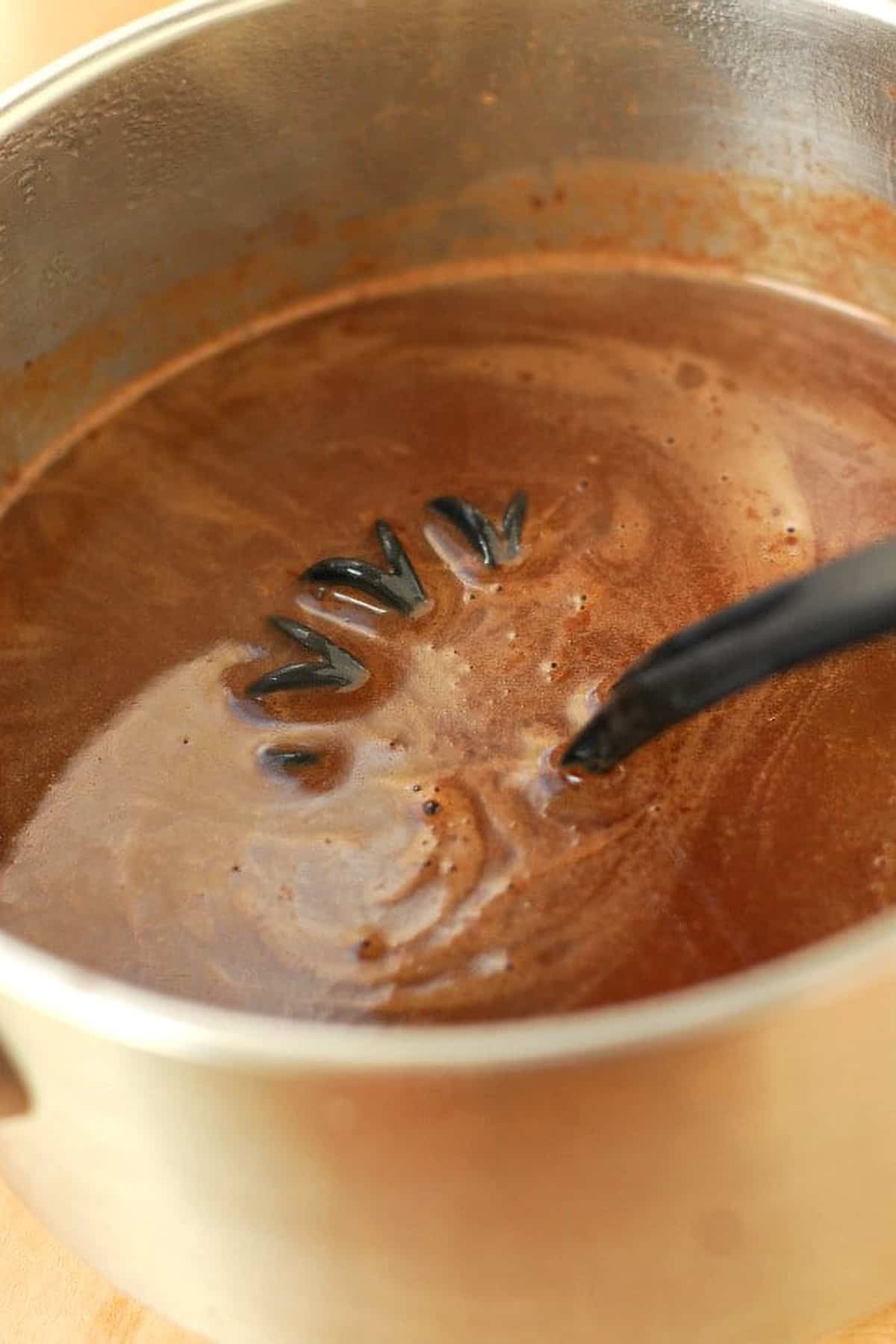 Mocha Punch syrup in a pot with a whisk.