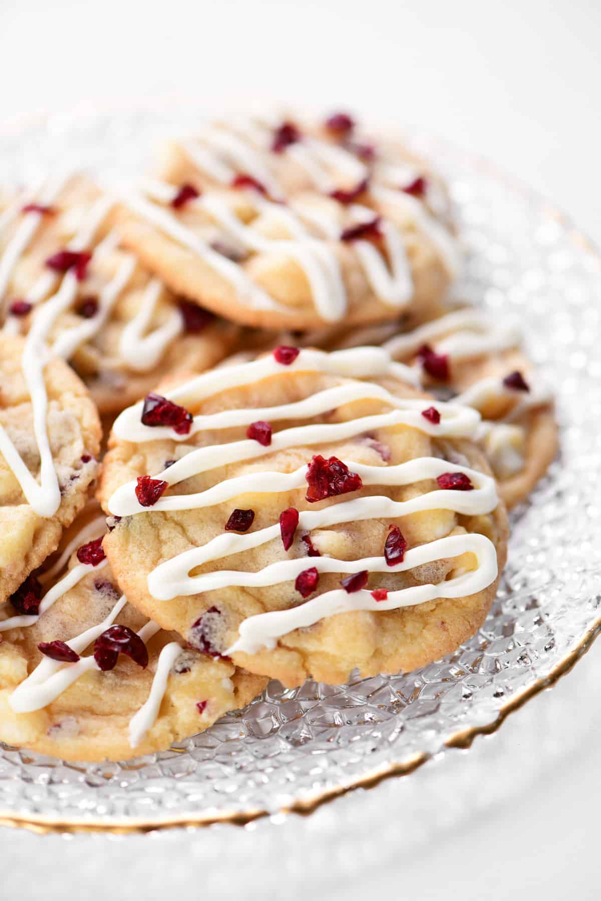 White chocolate cranberry cookies on a glass plate.