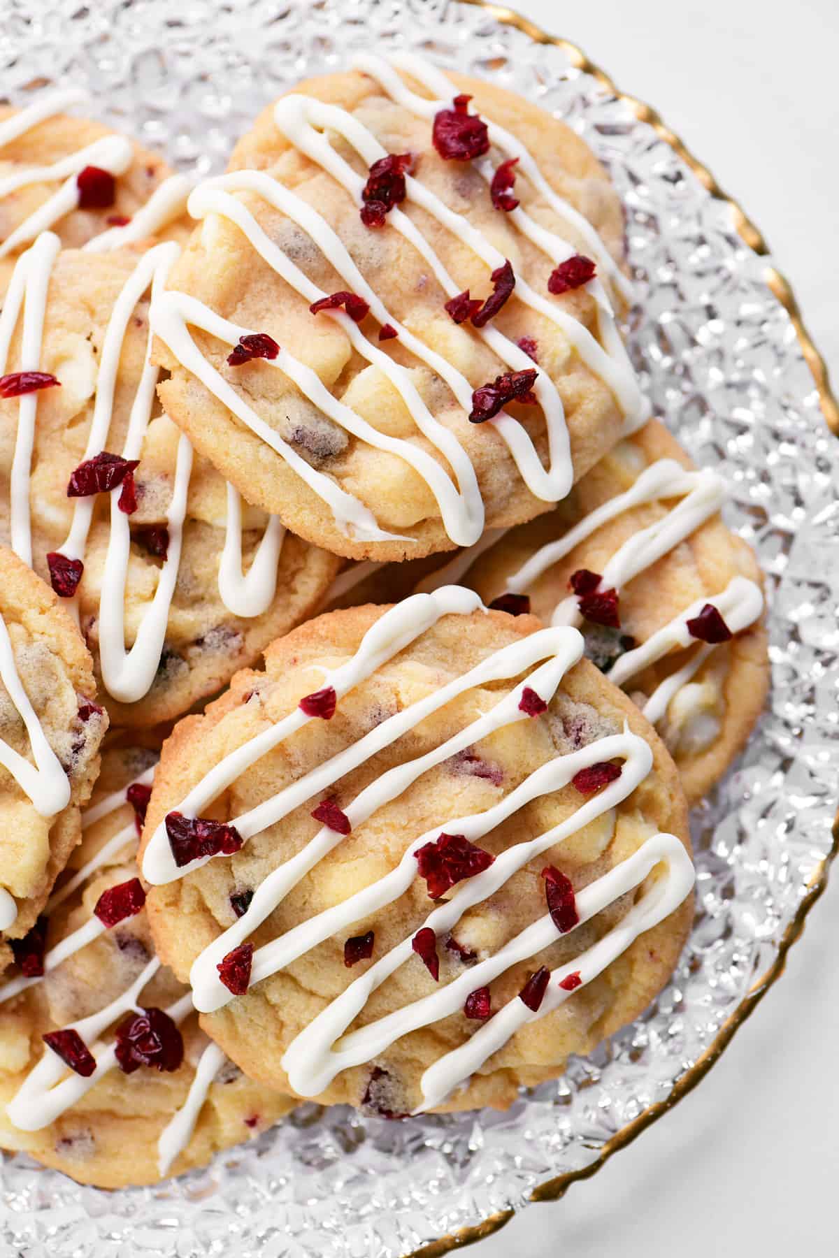 White chocolate cranberry cookies on a glass plate.