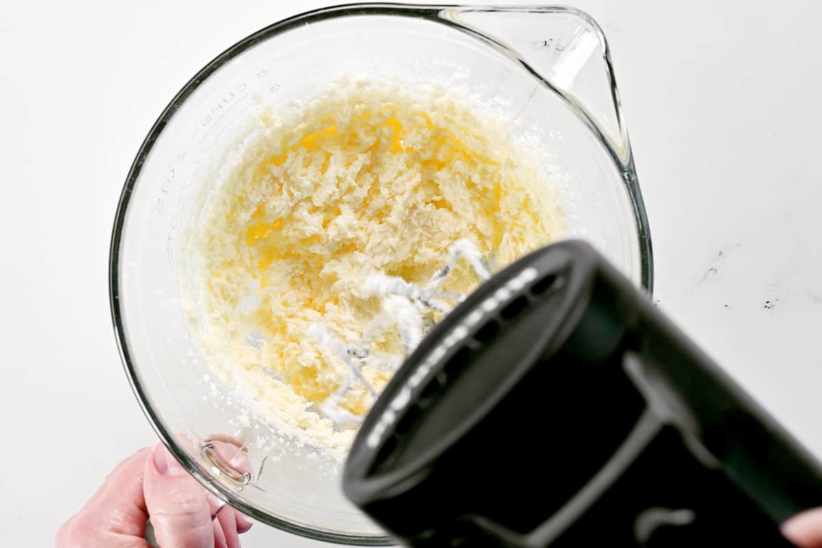 Using a hand mixer to cream the butter and sugar.