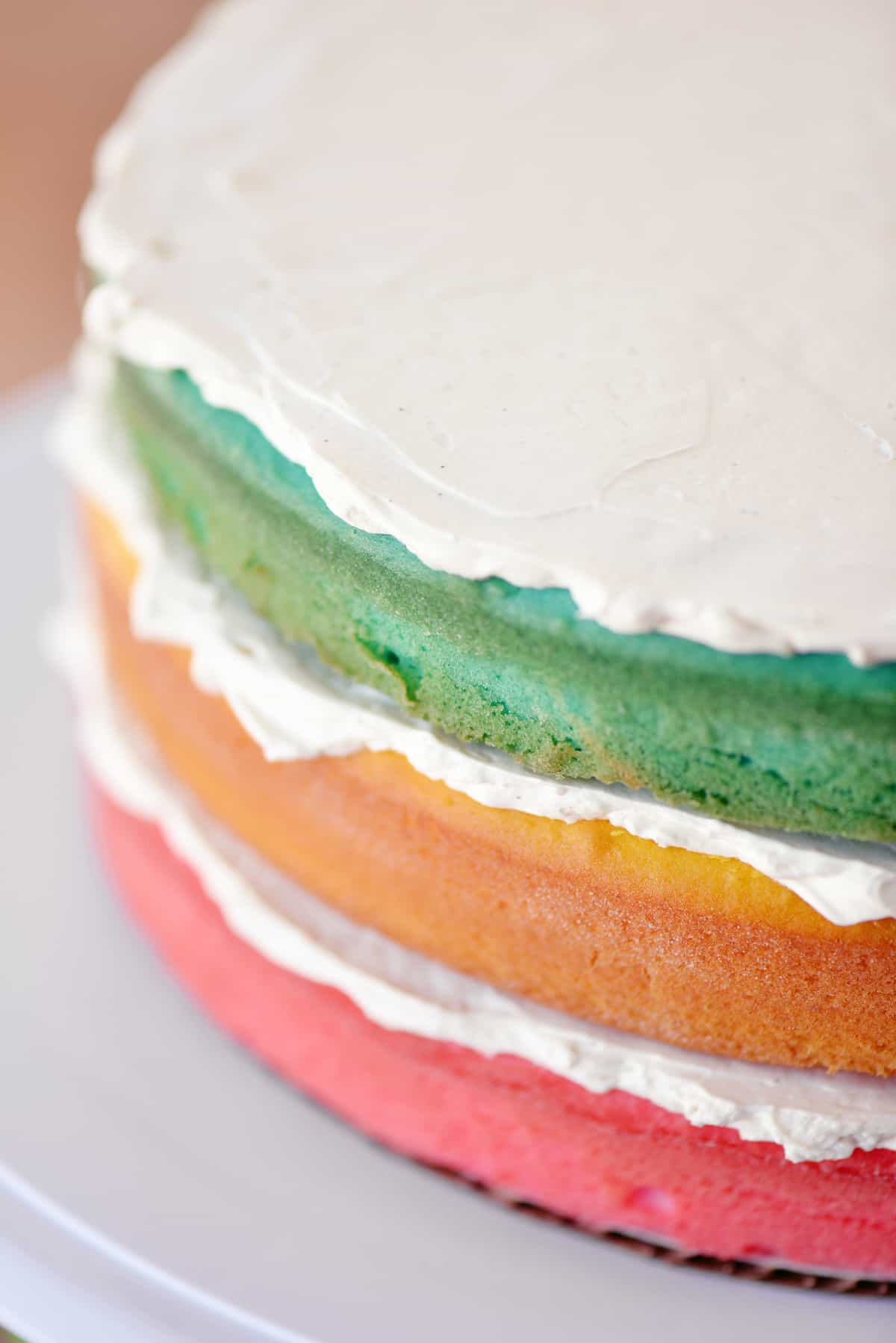 Add vanilla bean frosting to each of the three pastel layers.