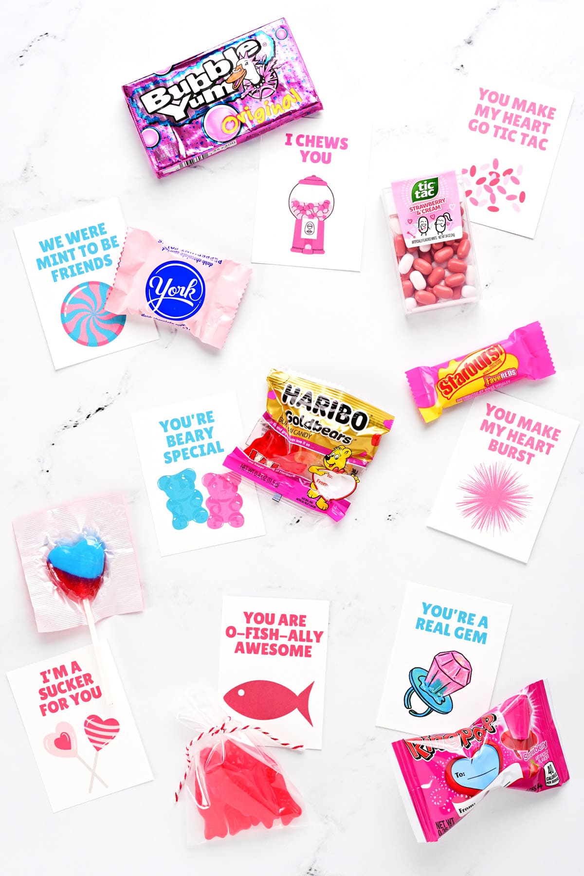 Candy and free printable valentine cards for kids on a countertop surface.
