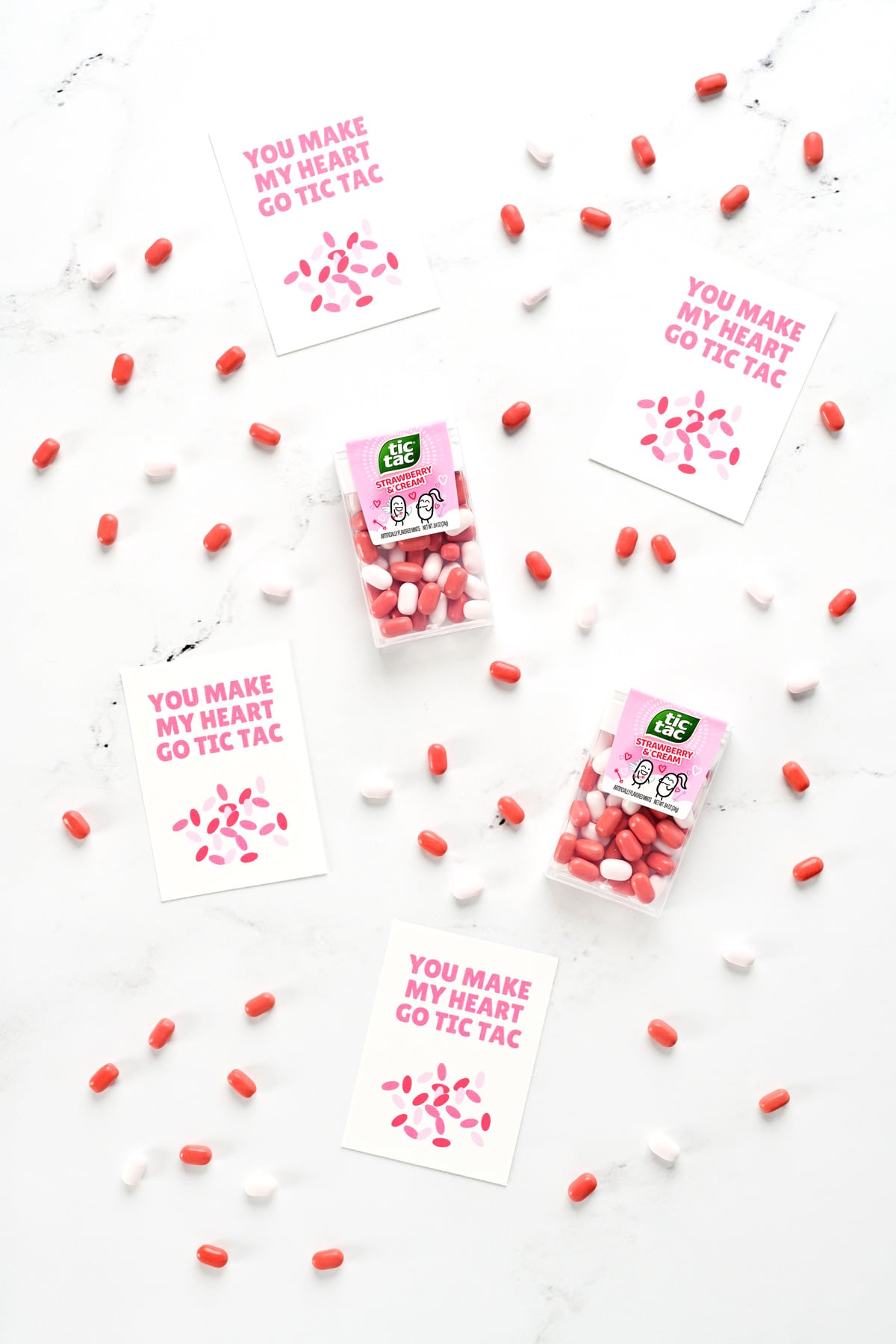 Strawberry & Cream Tic Tac candies and free printable valentines on a counter surface.