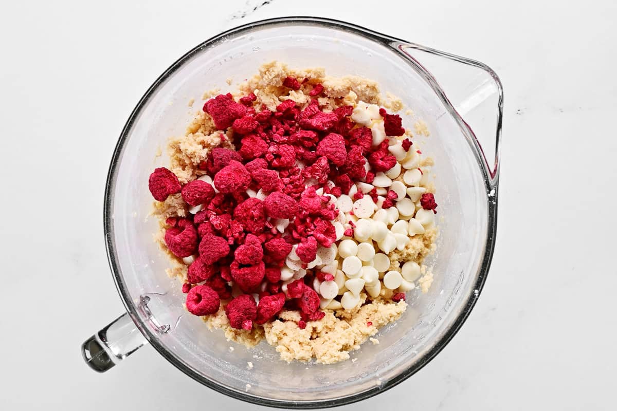 Add white chocolate chips and freeze dried raspberries to bowl.