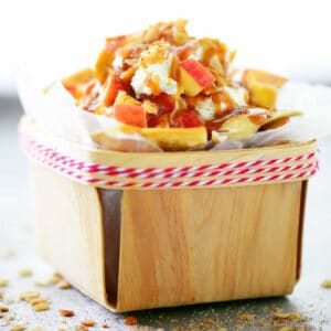 Apple nachos in a small wooden basket.