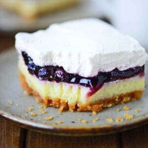 A slice of blueberry cheesecake dessert with a bite out of it.