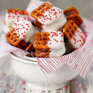 Candy bar pretzel bites with red sprinkles in a bowl.