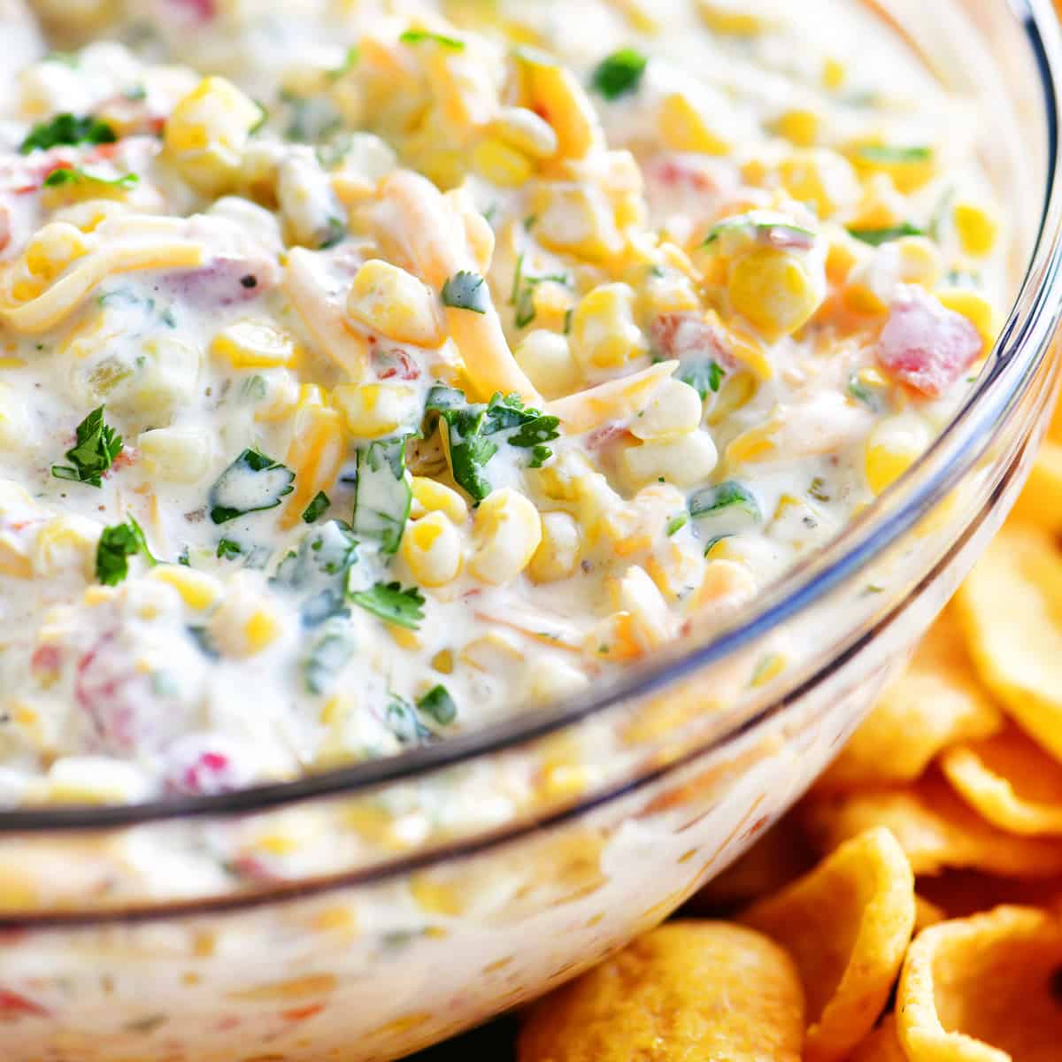 Corn dip in a bowl surrounded by Fritos.