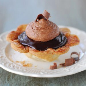European truffle pie on a white plate with chocolate curls.