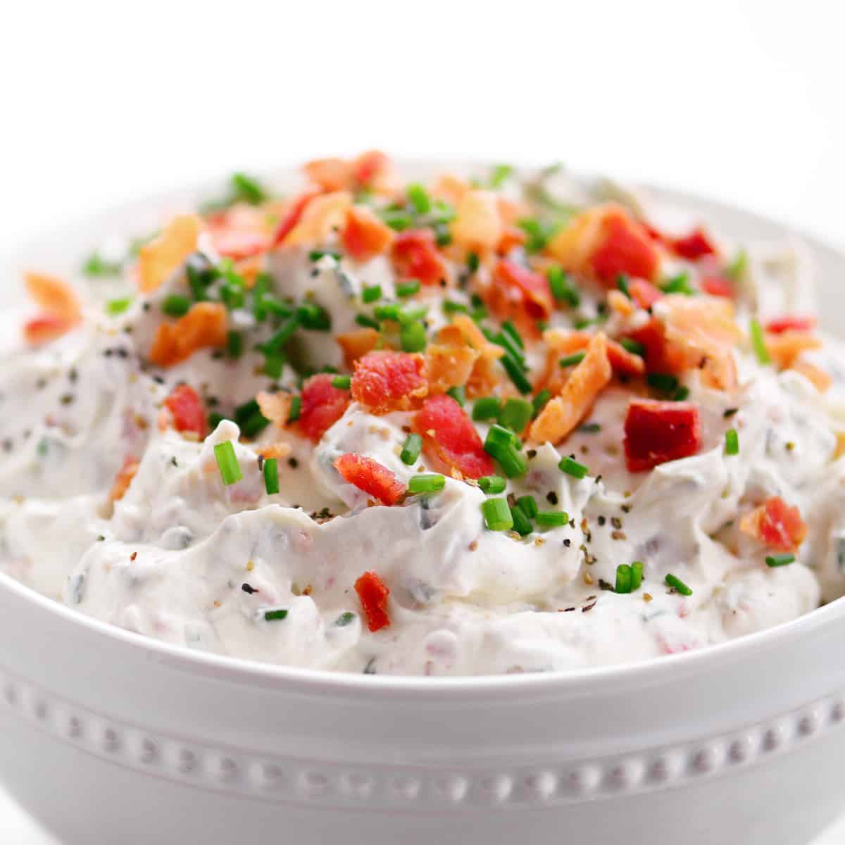 Loaded baked potato dip in a white bowl.