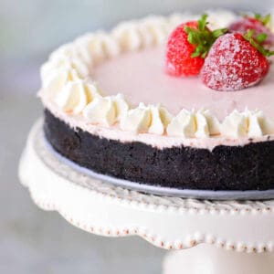 No bake strawberry cheesecake on a white cake platter.