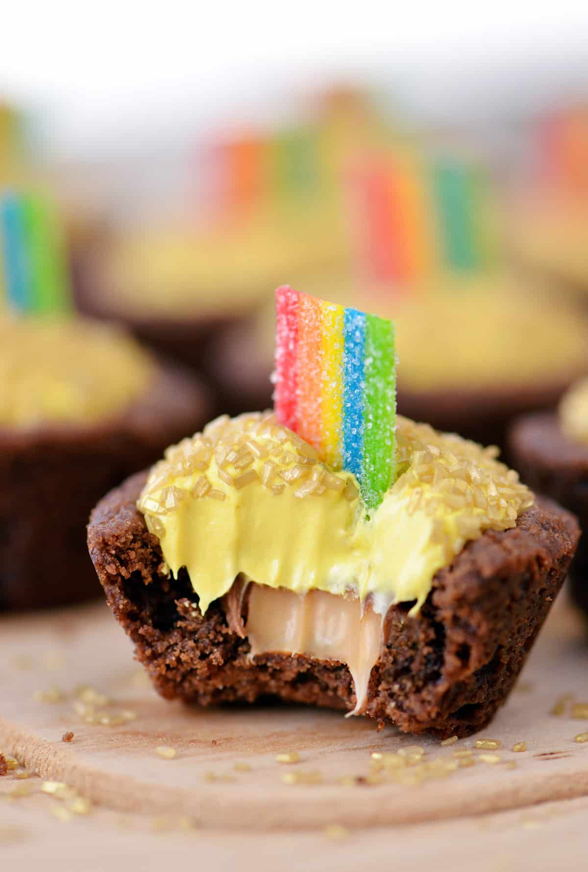 A rainbow pot of gold cookie cup with a bite out of it.