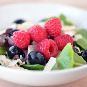 Raspberry spinach salad in a white bowl.