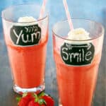Two glasses with strawberry smoothies inside.