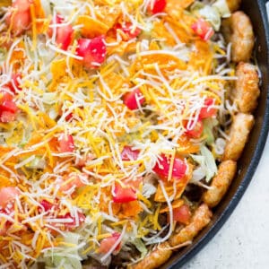 A tater tot taco pizza in a cast iron skillet.