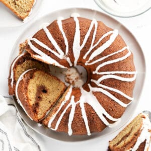 Top down view of a cinnamon Bundt cake and slices of the cake.