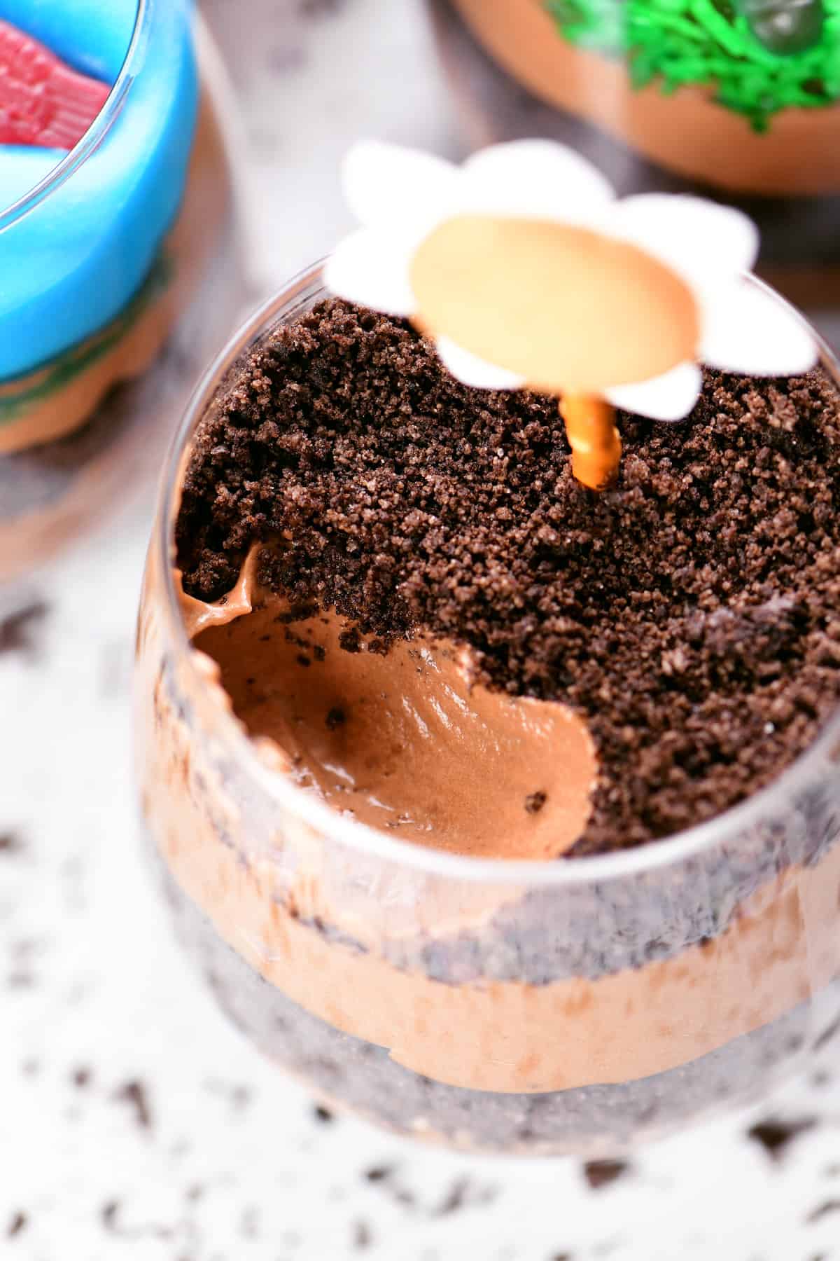 Smooth chocolate pudding topped with crushed Oreos dirt cake in cups.