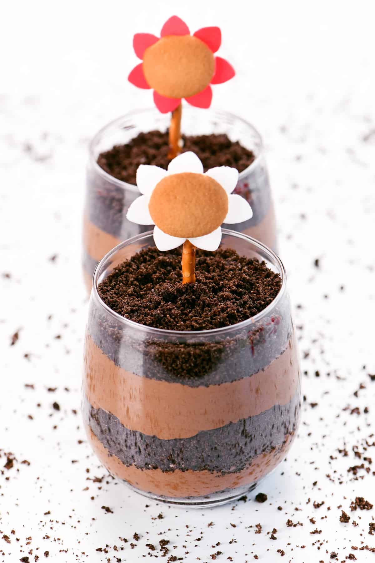 Dirt cake pudding cups with edible flowers on top.