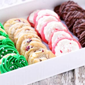 A white tray with four different kinds of Christmas cookies displayed inside.