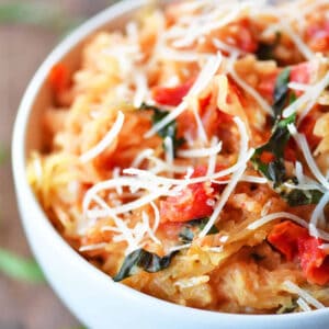 A white bowl with tomato basil spaghetti squash inside.