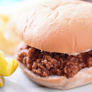 Sloppy joes in a bun with a pickle.