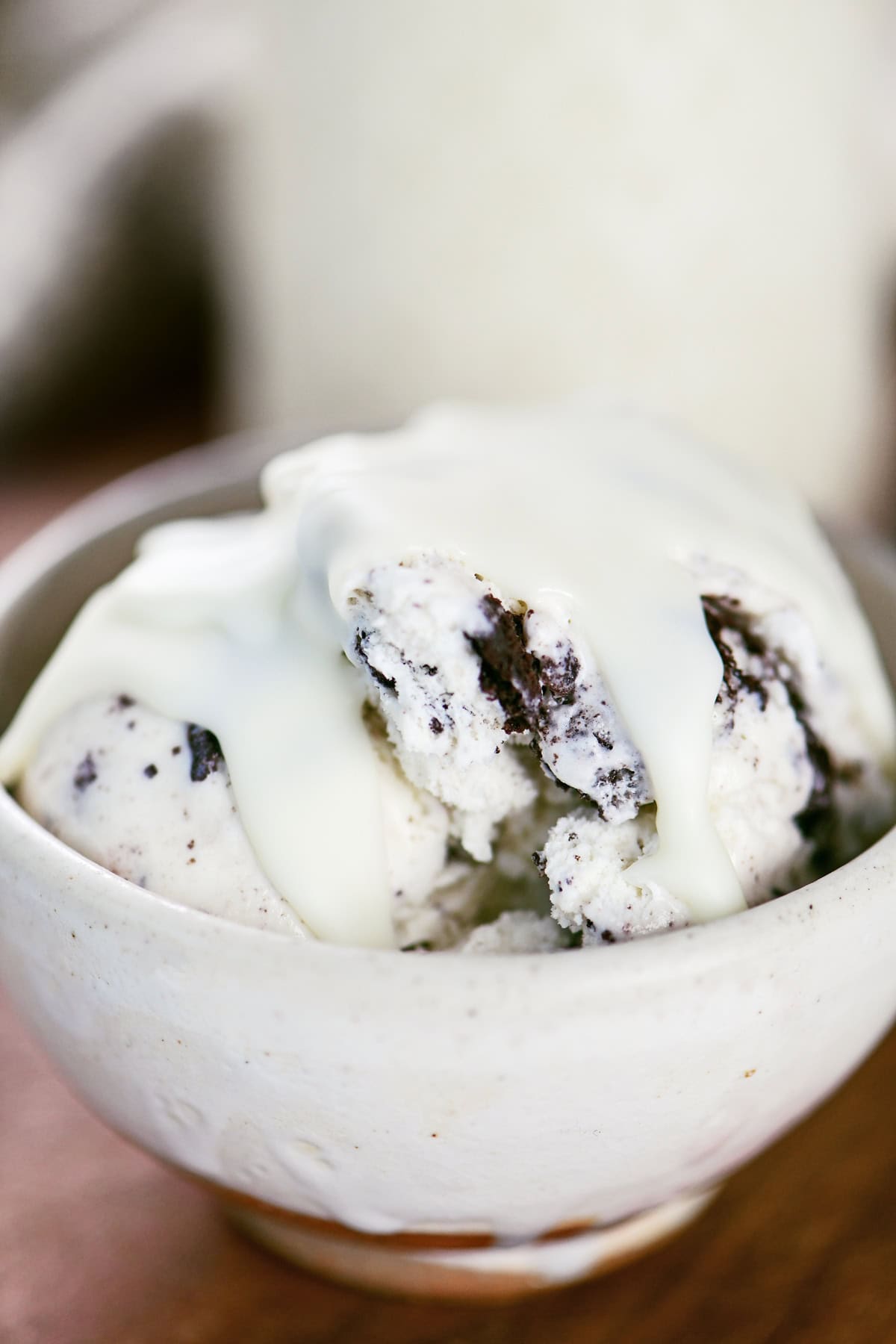 White chocolate magic shell on cookies and cream ice cream in a bowl.