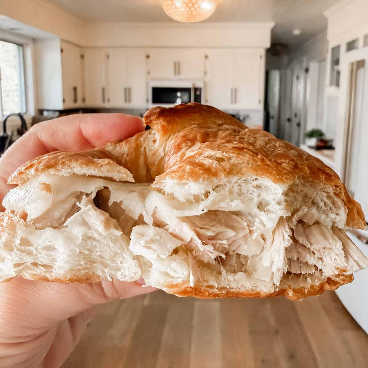 Tonia Larson holding a turkey croissant.