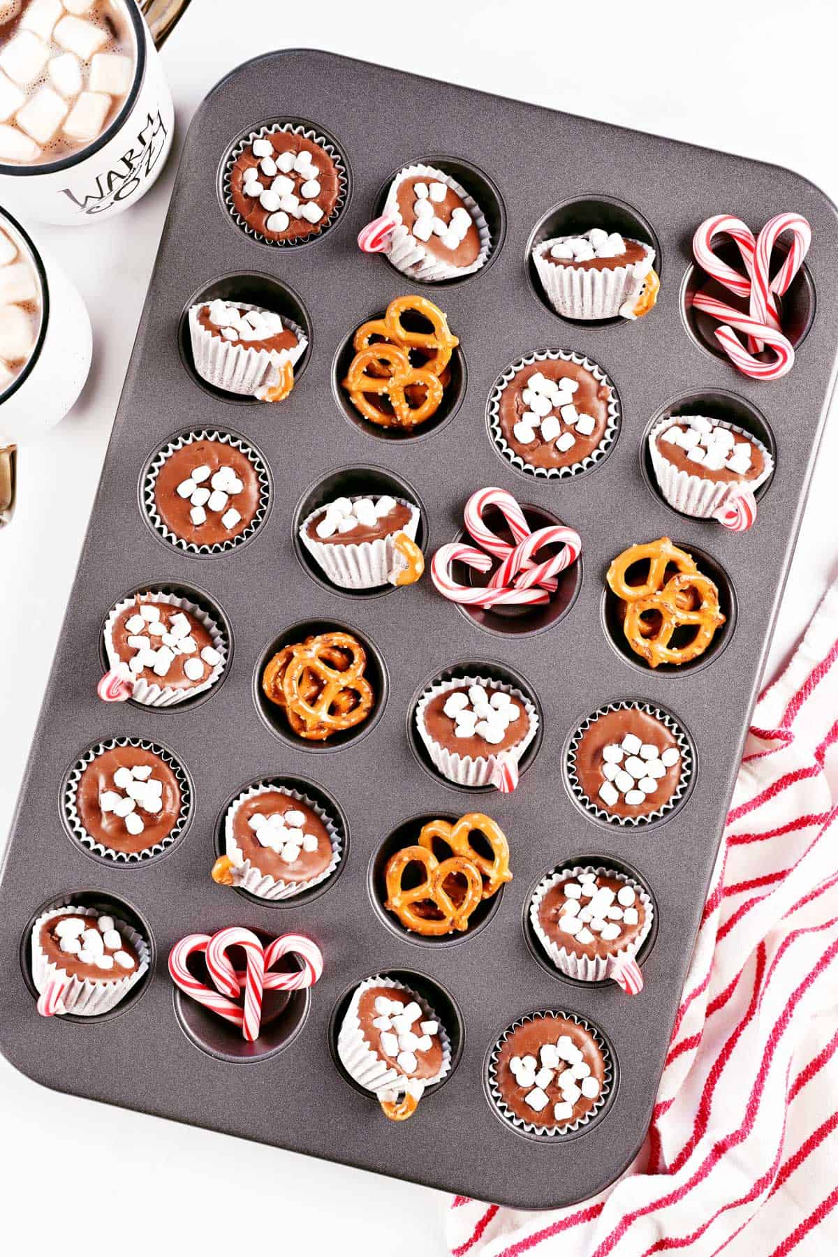 Hot chocolate fudge, pretzels, and mini candy canes in a cupcake pan.