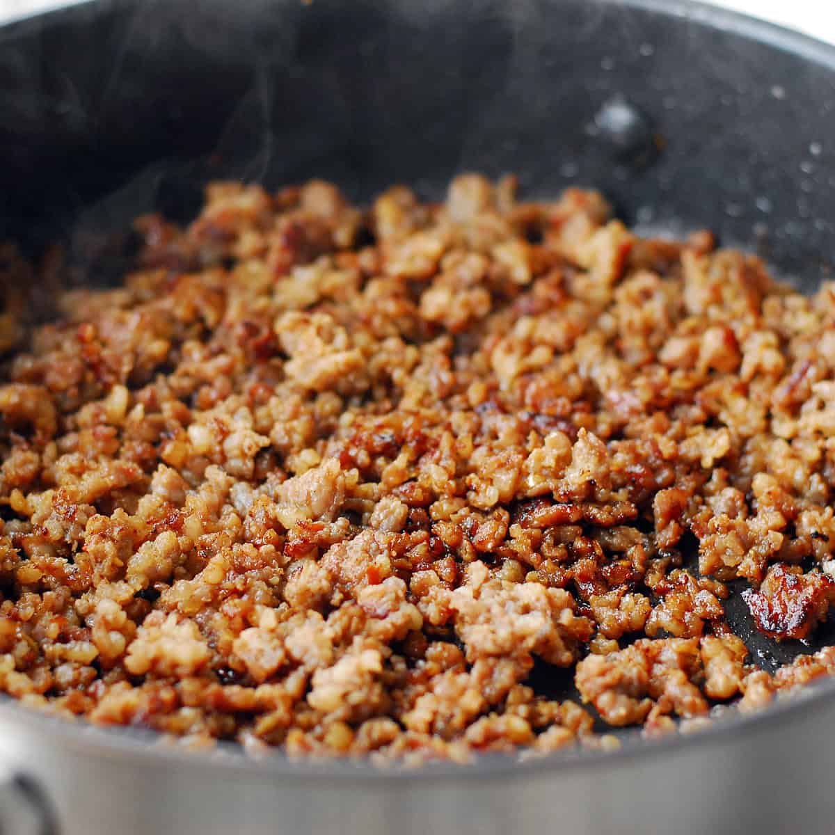 Browned ground sausage in a skillet.