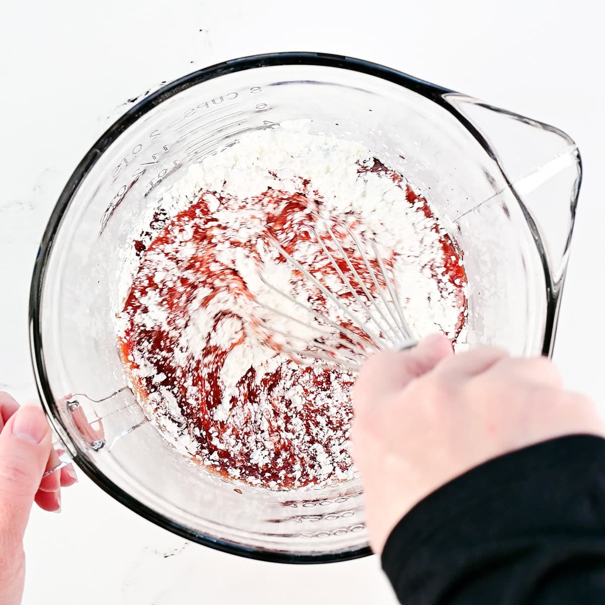 Whisking ingredients in a glass bowl.