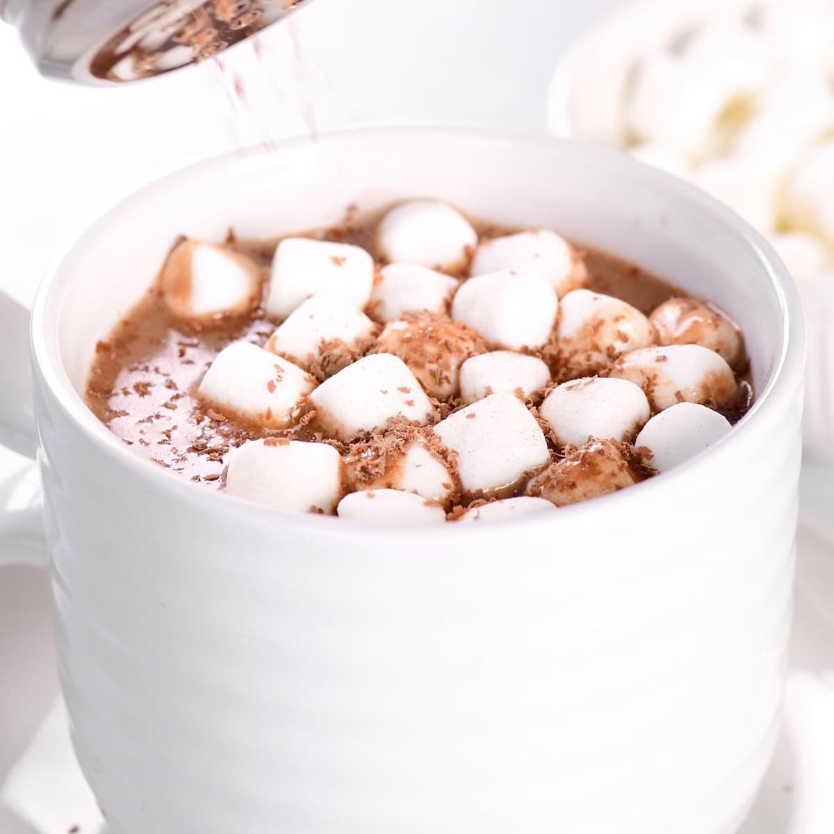 Sprinkling chocolate shavings on top of the marshmallows.