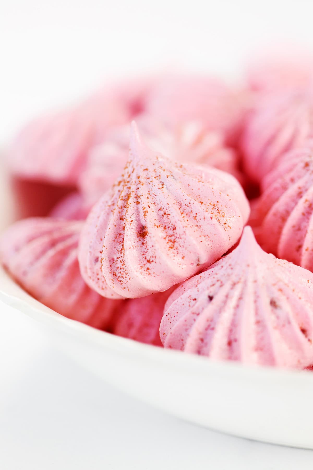 Strawberry meringue cookies in a bowl.