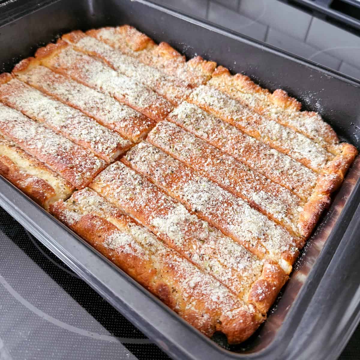 Cut cottage cheese breadsticks in a pan.