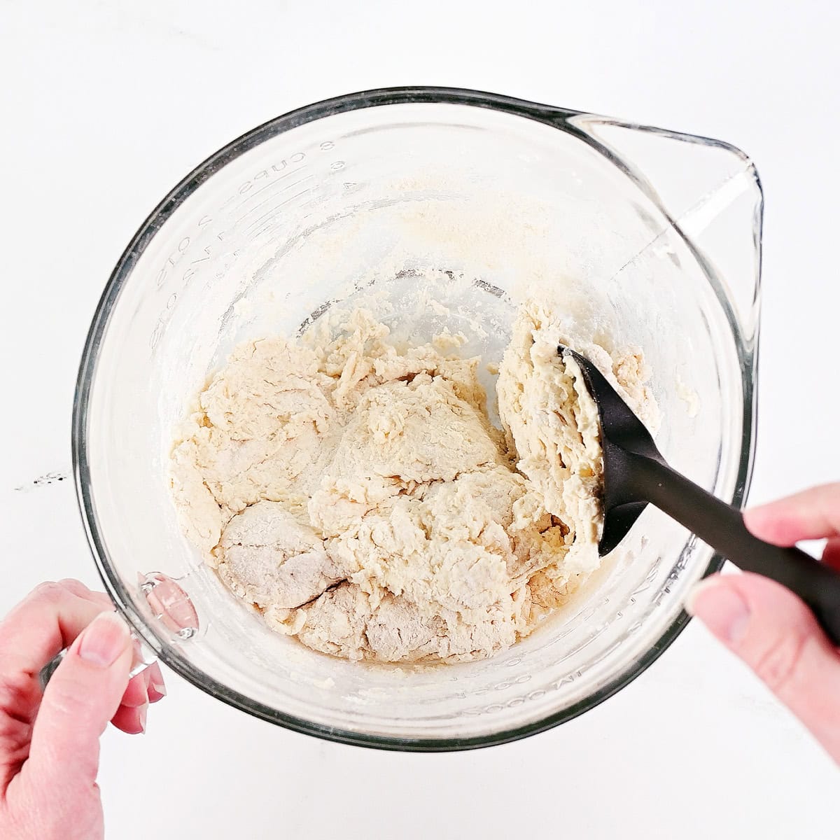 Mixing dough in a glass bowl.