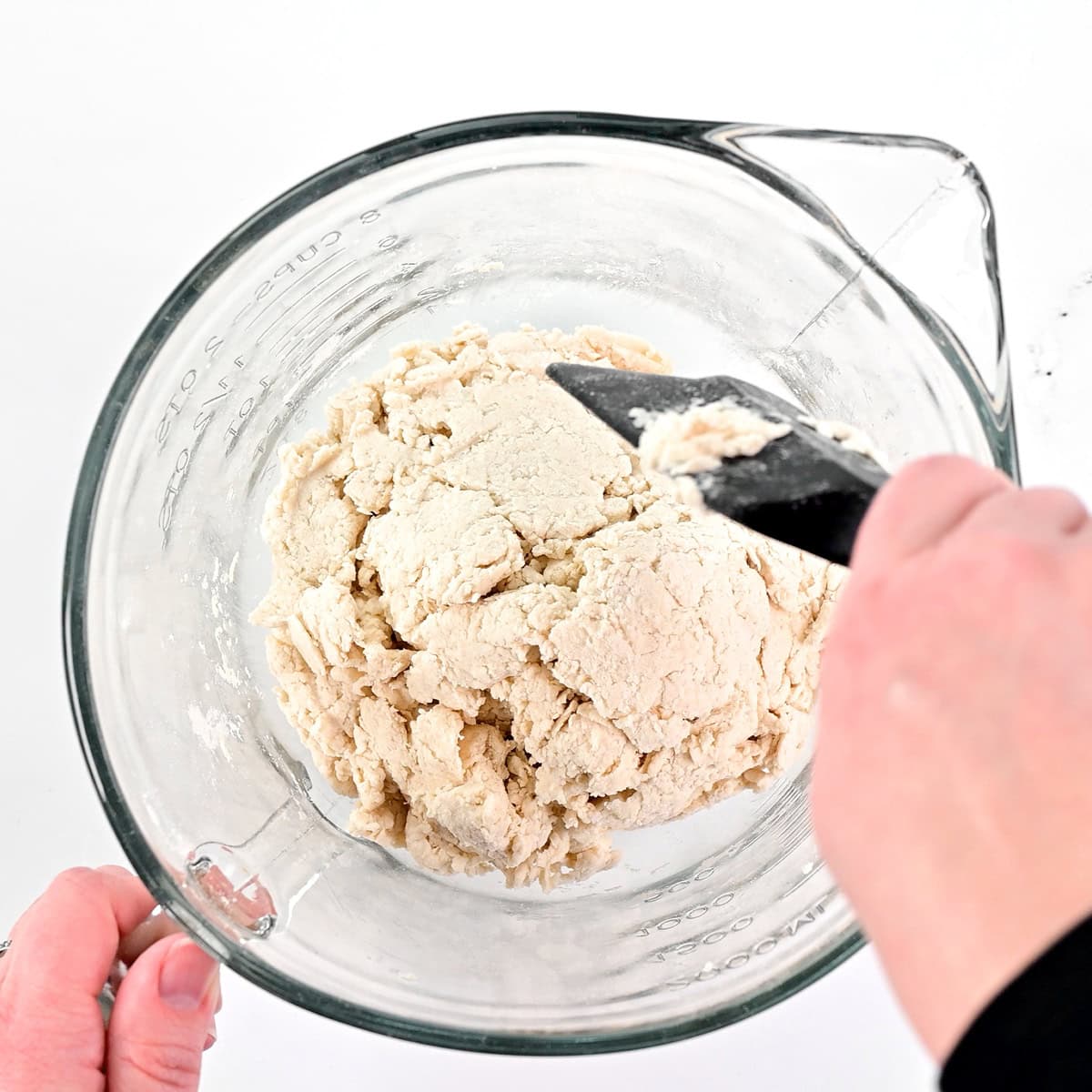 Mixing dough in a glass bowl.