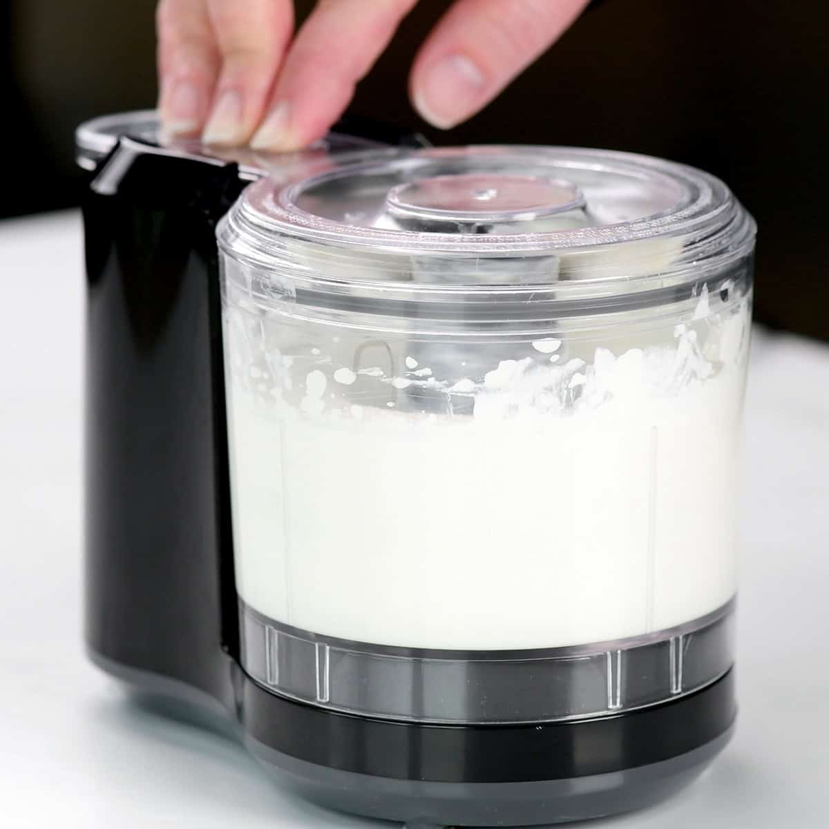 Blending cottage cheese in a mini food processor.