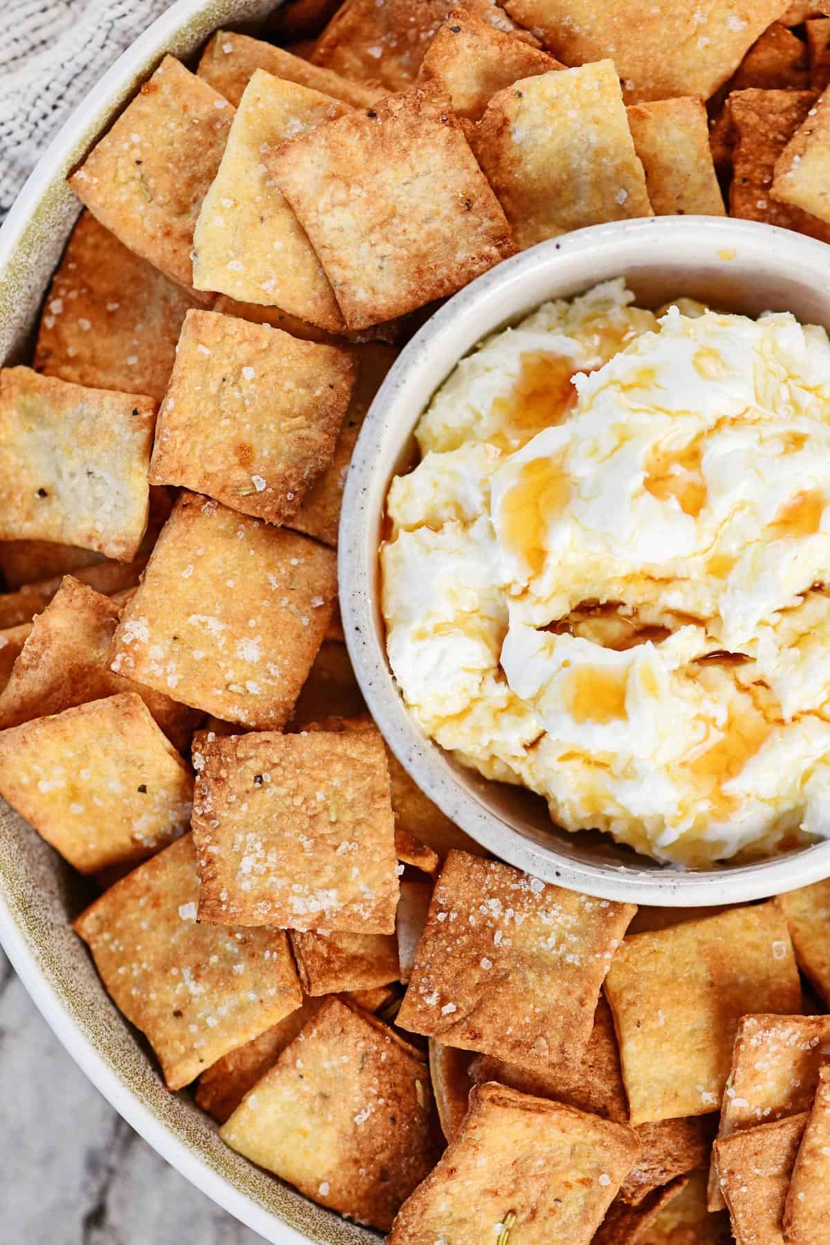 Cottage cheese crackers in a round tray with a bowl of dip in the center.