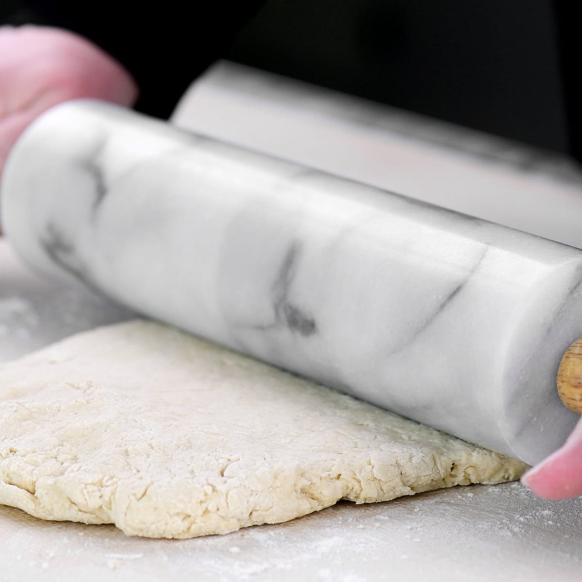 Rolling dough out with a marble rolling pin.