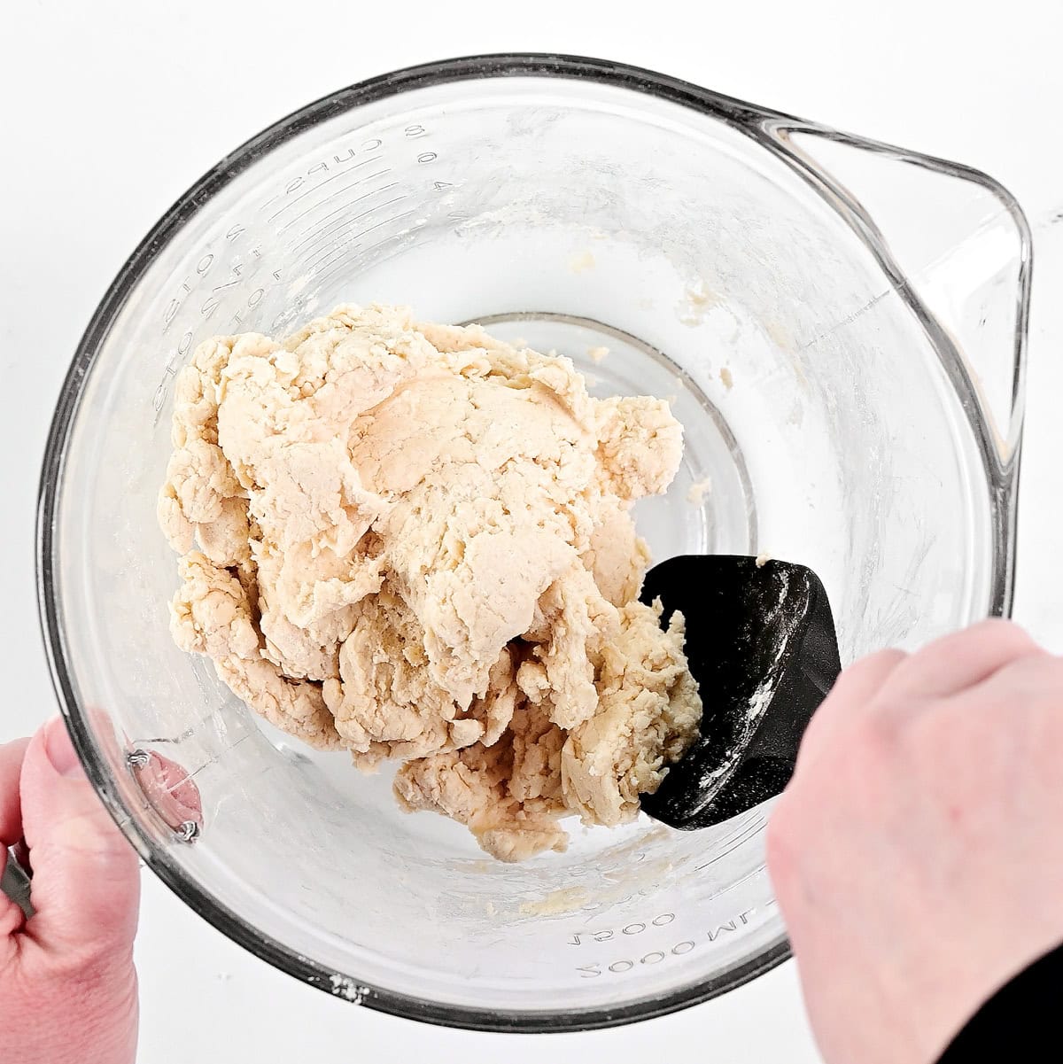 Mixing dough in a glass bowl.