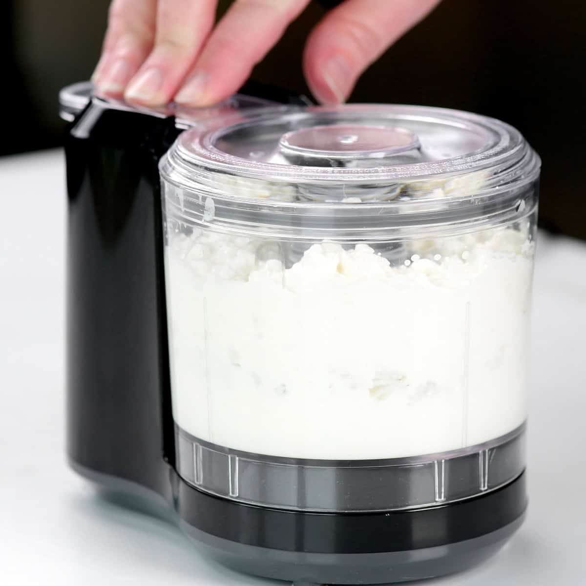 Blending cottage cheese in a mini food processor.