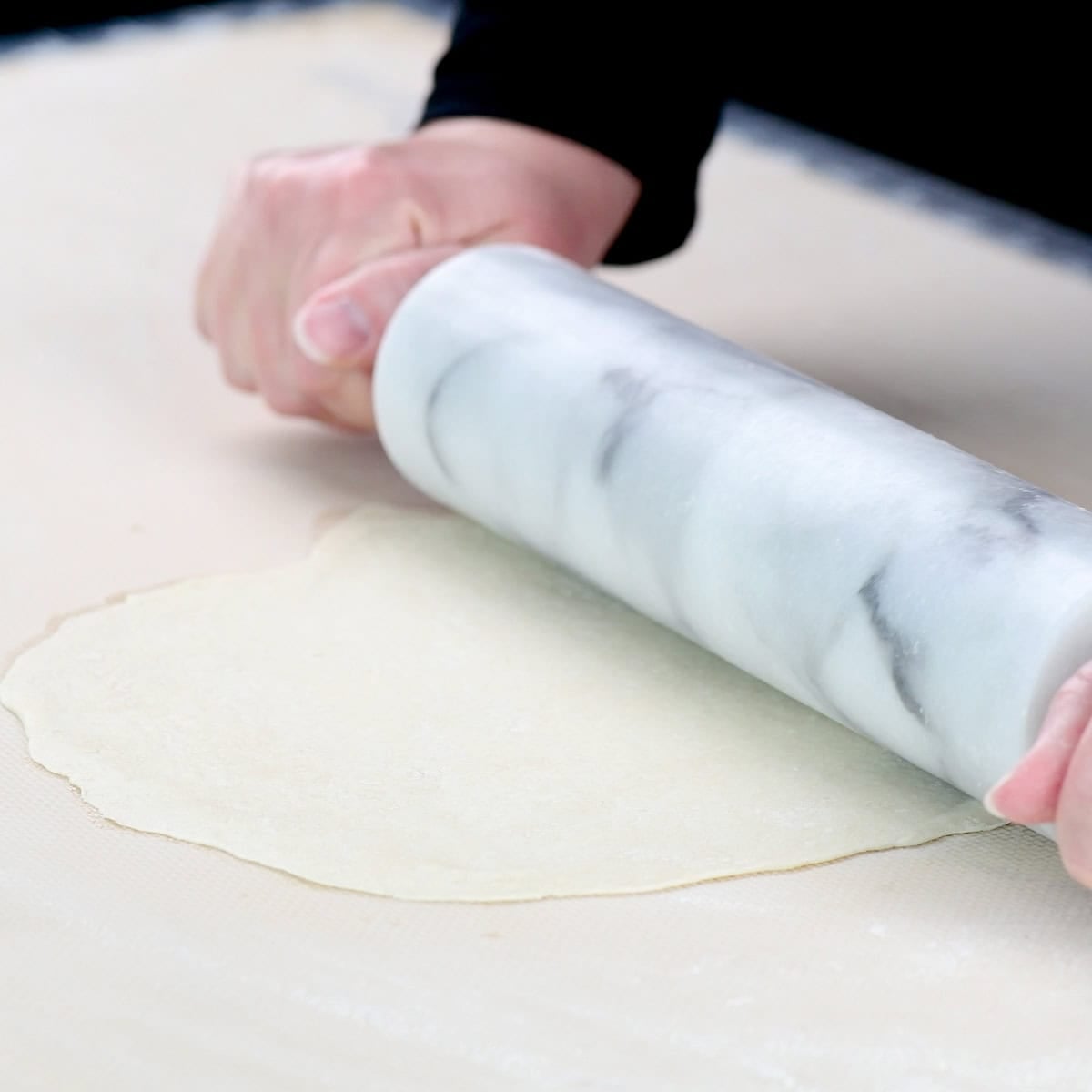 Rolling out dough with a marble rolling pin.