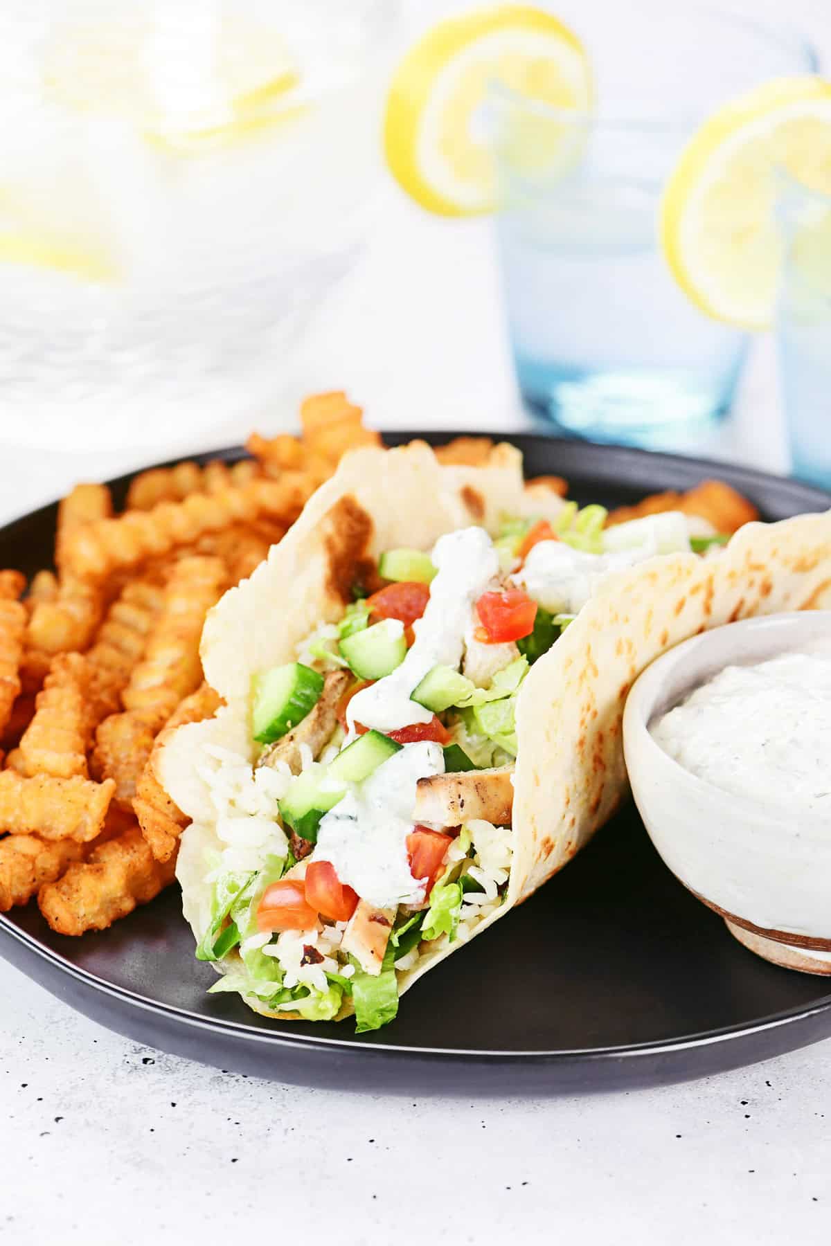 Greek chicken wrap with fries and dipping sauce.