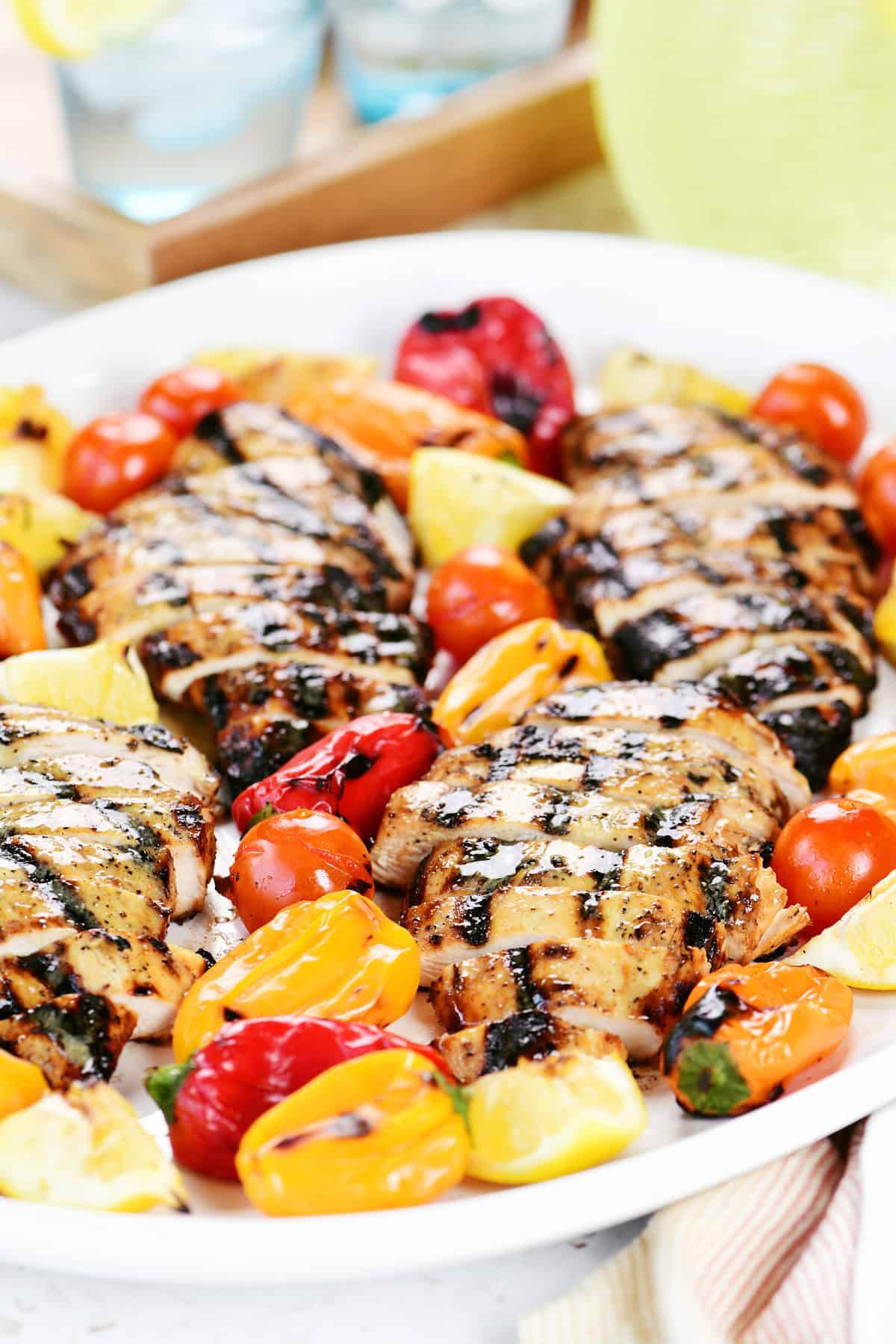 Grilled Greek chicken marinade grilled chicken on a platter with grilled peppers.