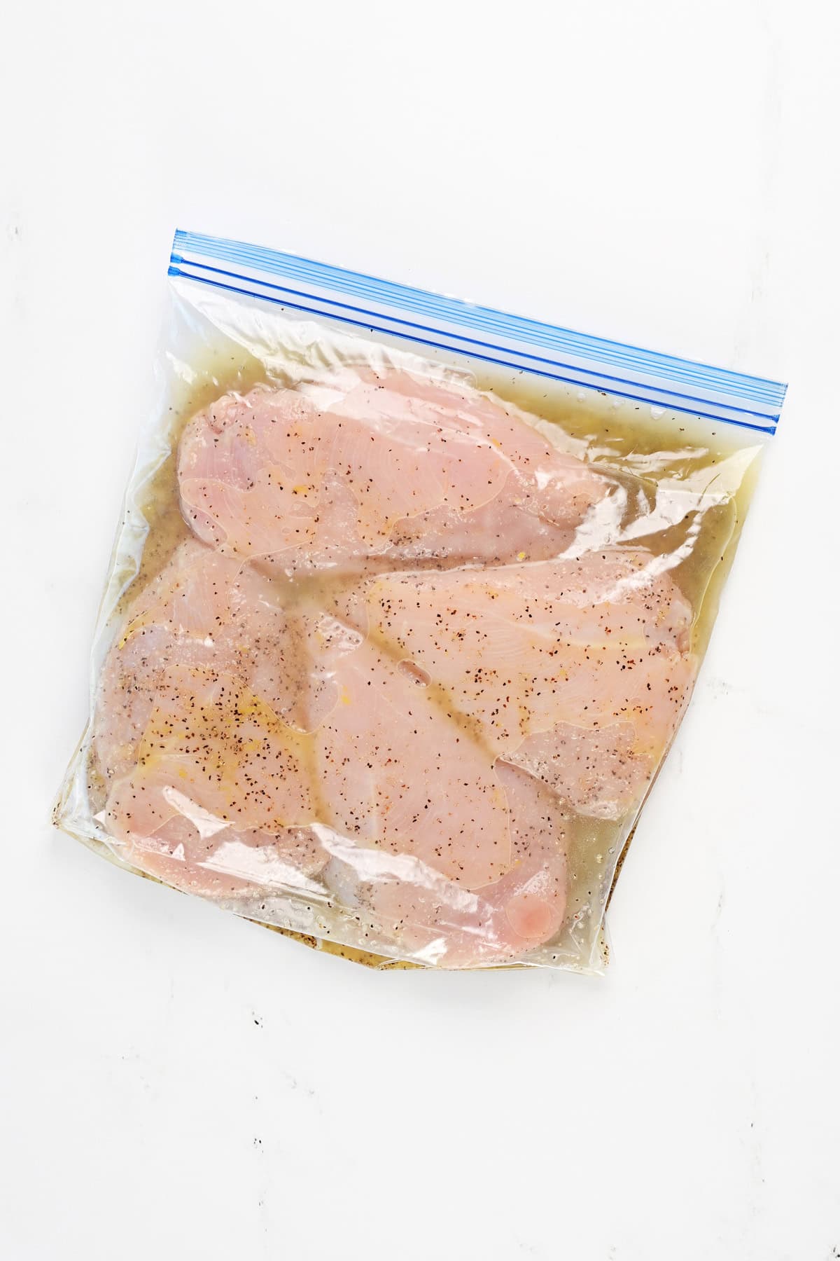 Lemon pepper chicken marinade chicken breasts in a gallon size bag.