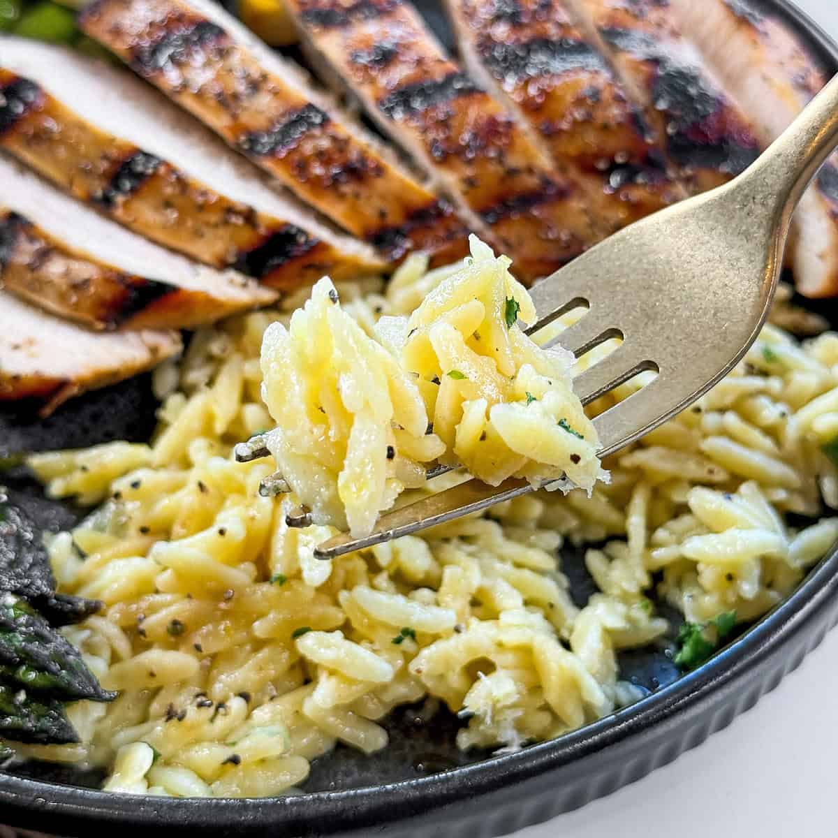 Creamy lemon orzo on a fork.