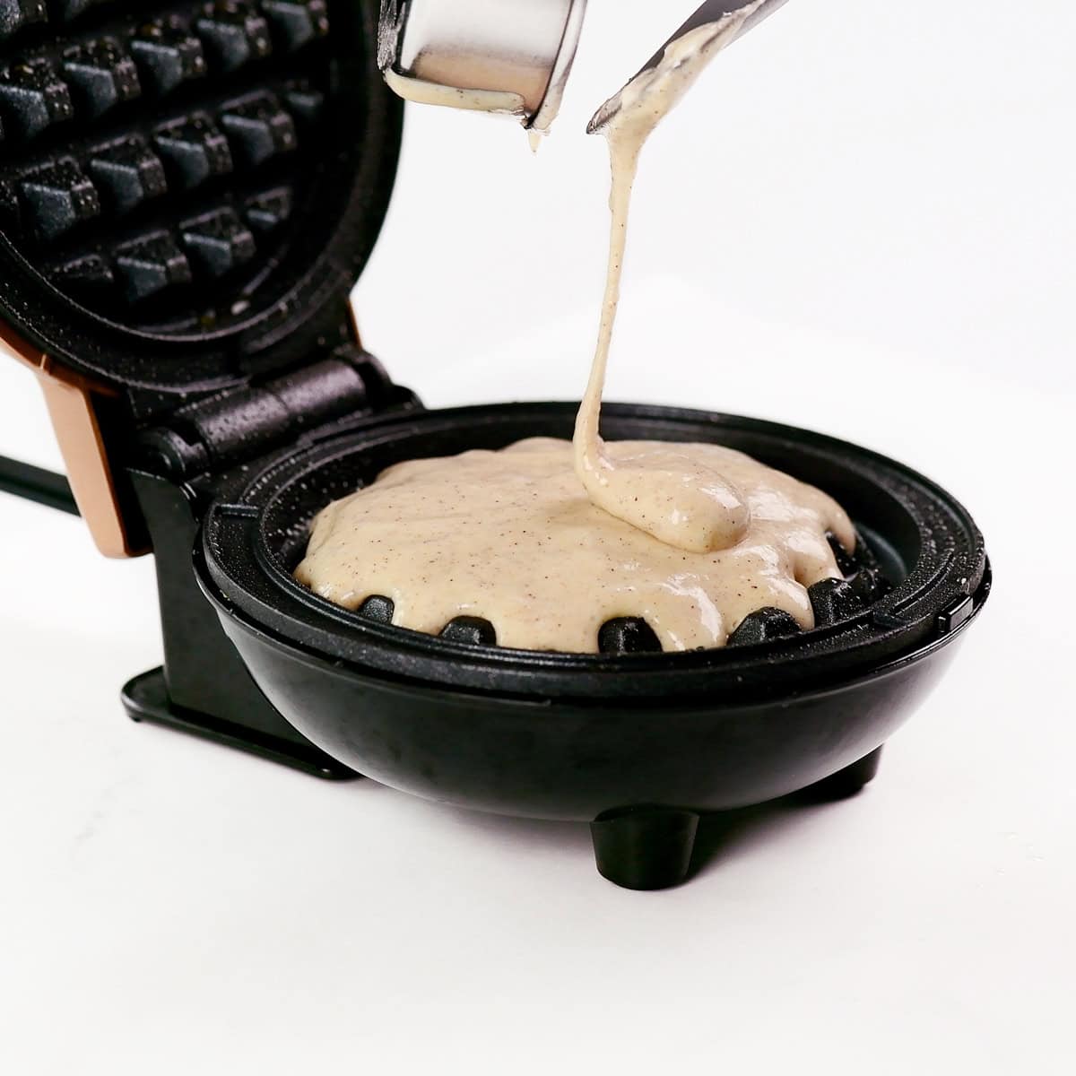 Pouring batter into a waffle iron.