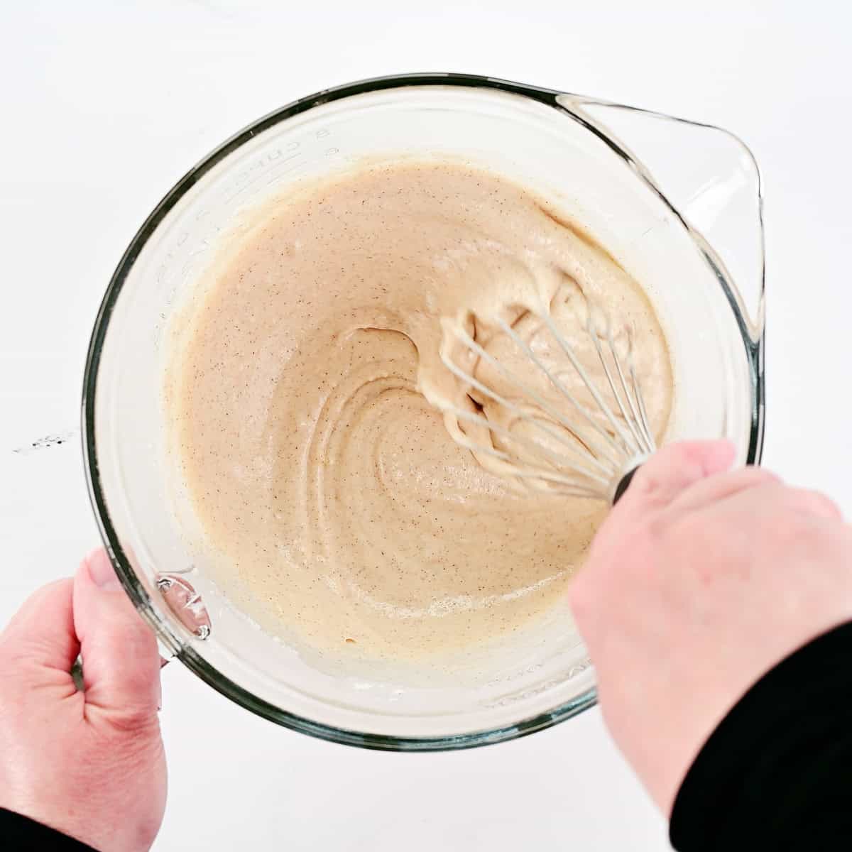 Whisking batter in a glass bowl.