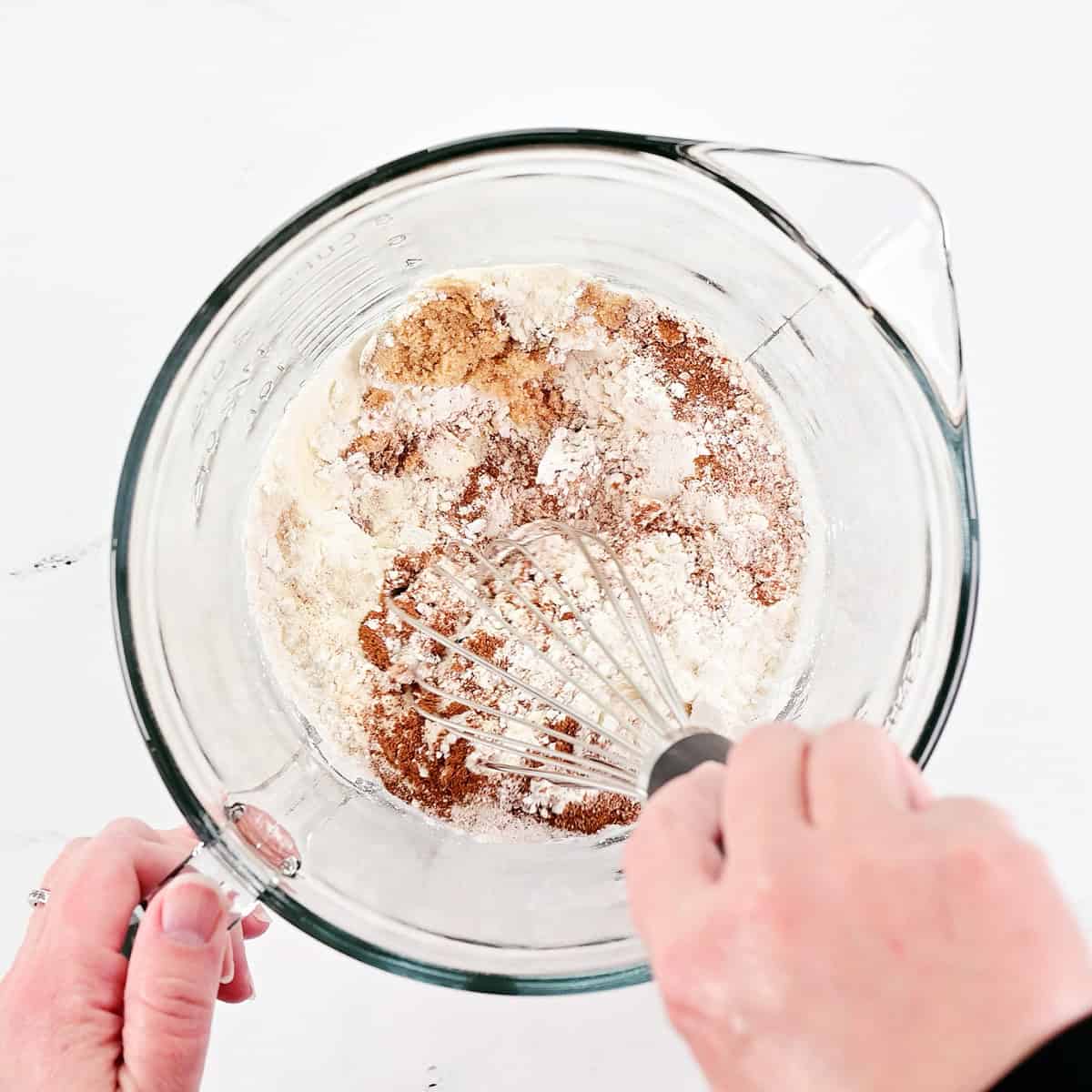 Whisking dry ingredients in a glass bowl.