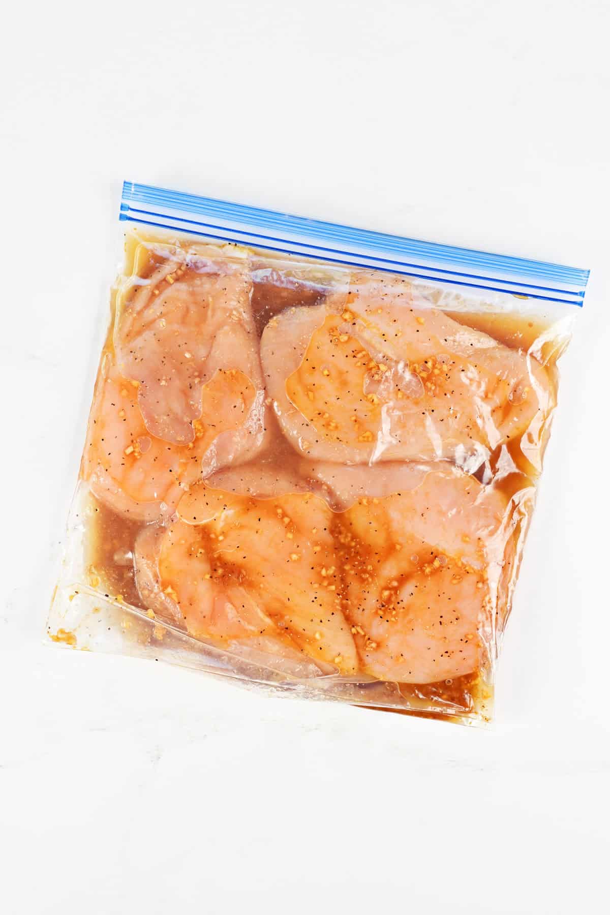 Teriyaki chicken marinade on chicken in a bag.