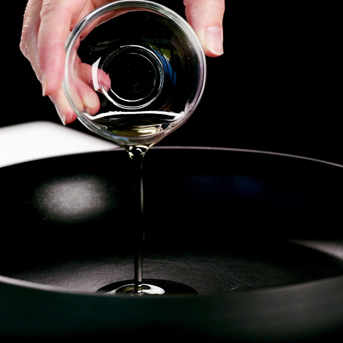 Pouring vegetable oil into a skillet.